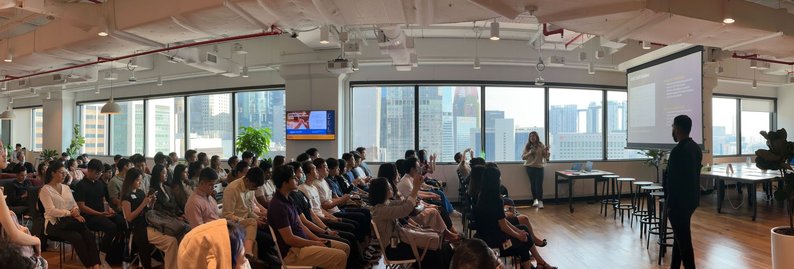 EdTech founder event at AWS Singapore — packed auditorium with city skyline backdrop